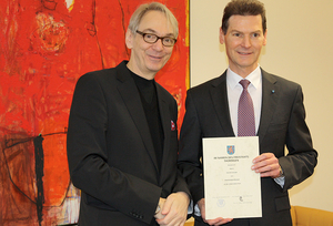 Unipräsident Prof. Dr. Walter Bauer-Wabnegg überreicht Gerald Grusser die Urkunde zur Honorarprofessur.