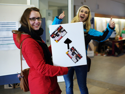 zwei Studentinnen mit einem Hocker mit der Aufschrift "Dein Studienplatz"